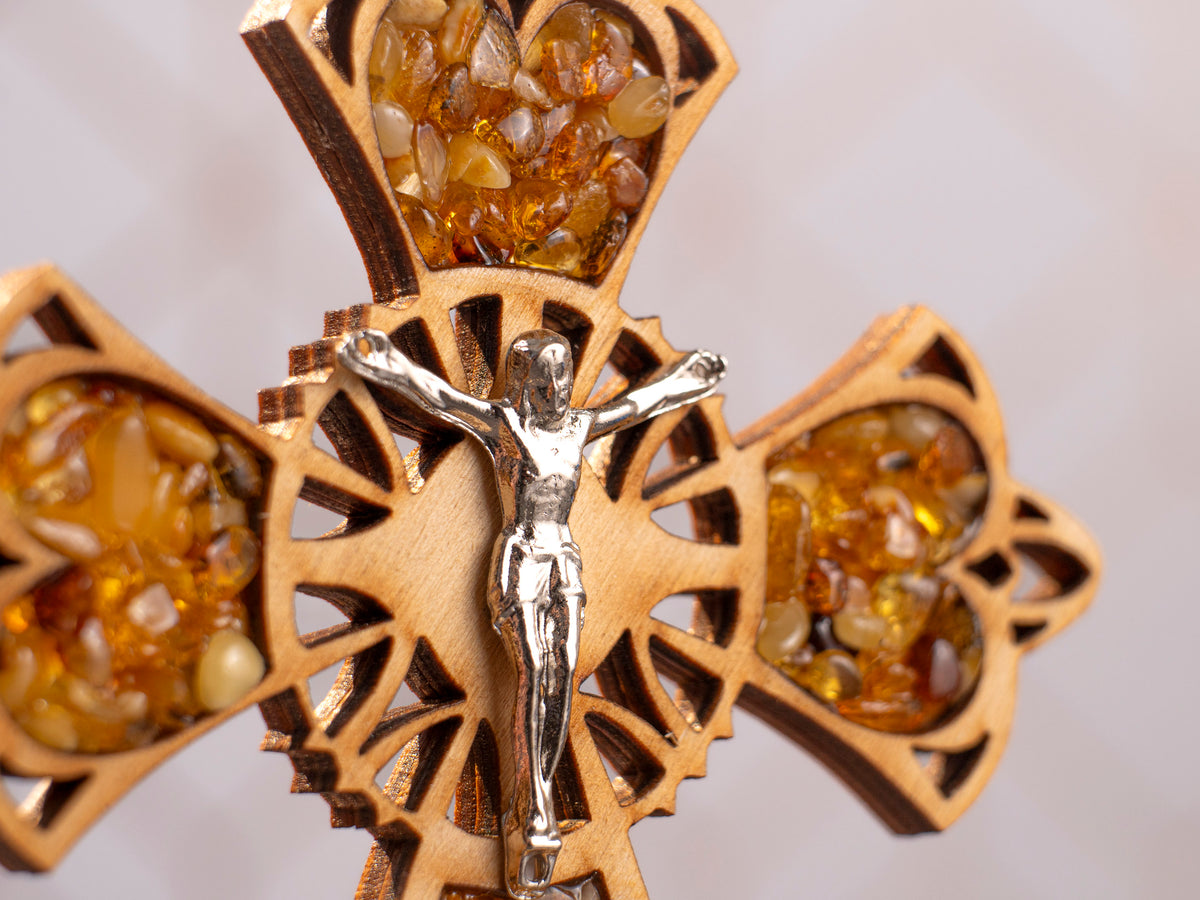 Close-up of the centre of the wooden cross with a crucifix figure and amber pieces along the arms.