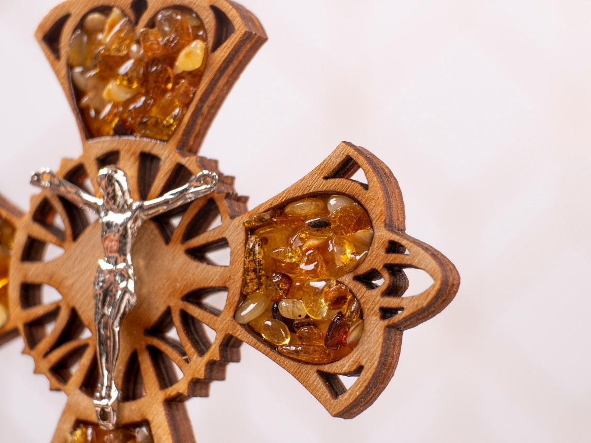 Angled close-up of the standing wooden cross with amber pieces and a crucifix figure.