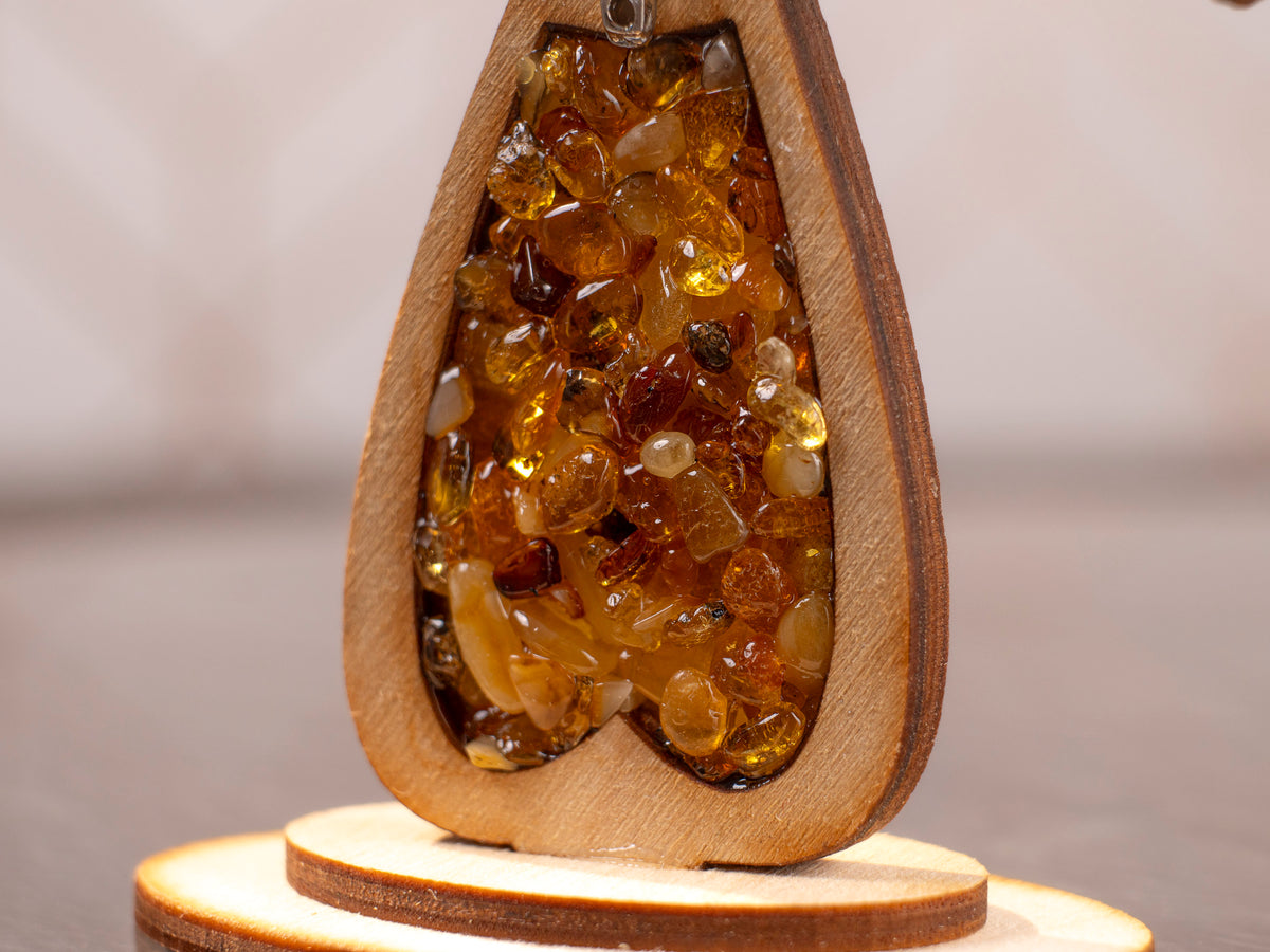 Close-up of the lower section and round base of the wooden cross with amber pieces.